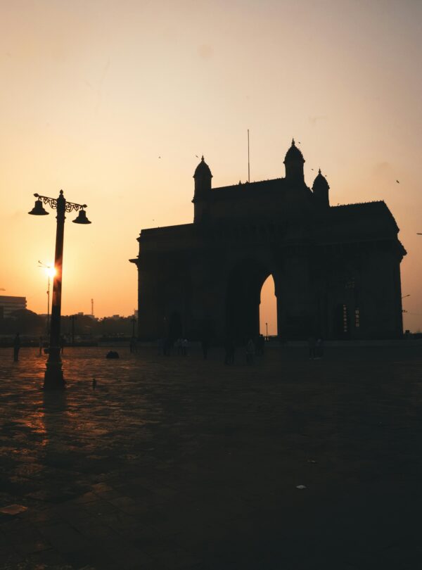Dramatic silhouette of the Gateway of India during sunset in Mumbai.