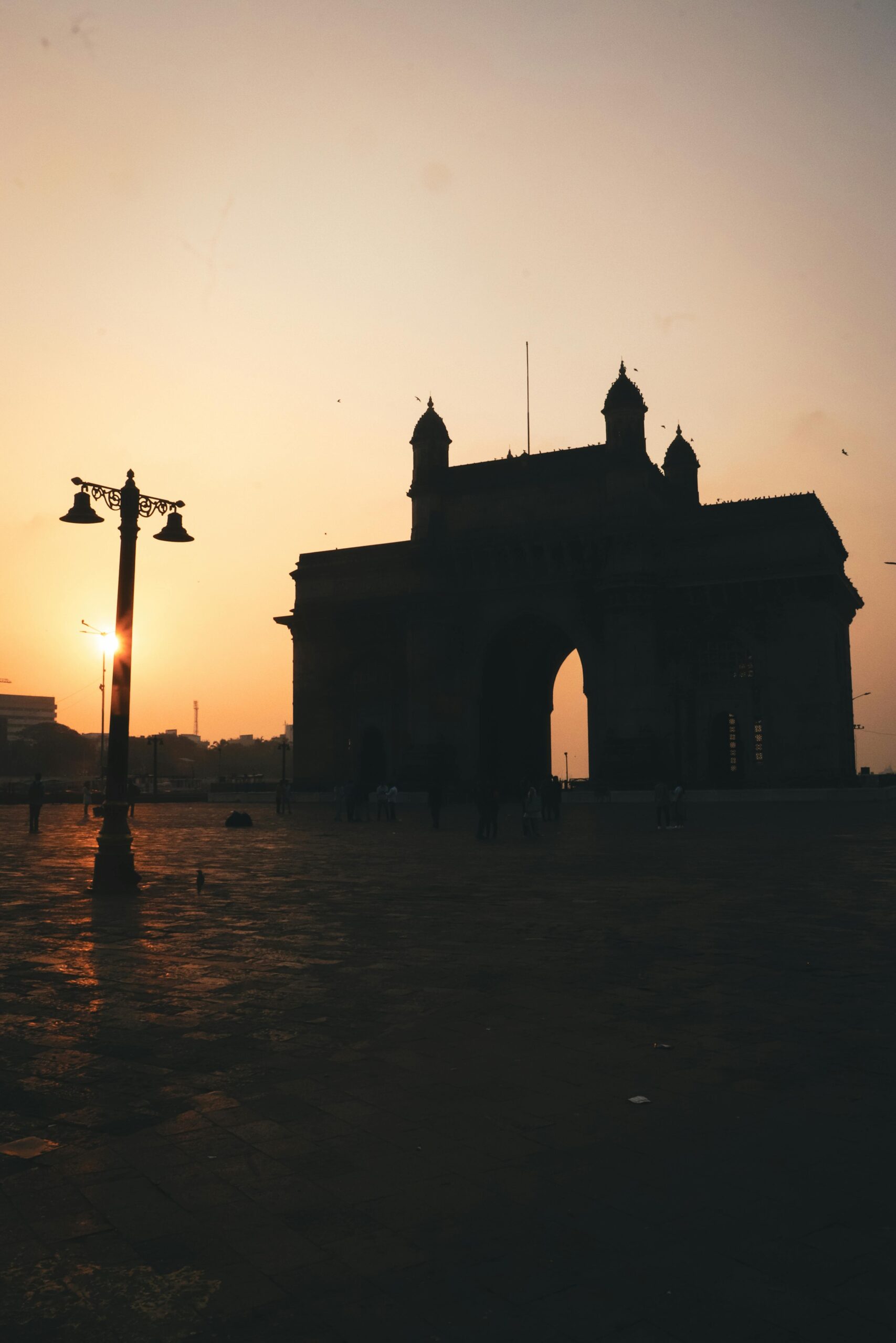 Dramatic silhouette of the Gateway of India during sunset in Mumbai.